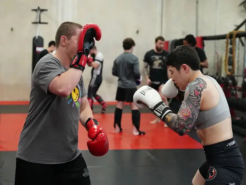 Beginner Muay Thai training focused on punching combinations, stance control, and partner drills in class
